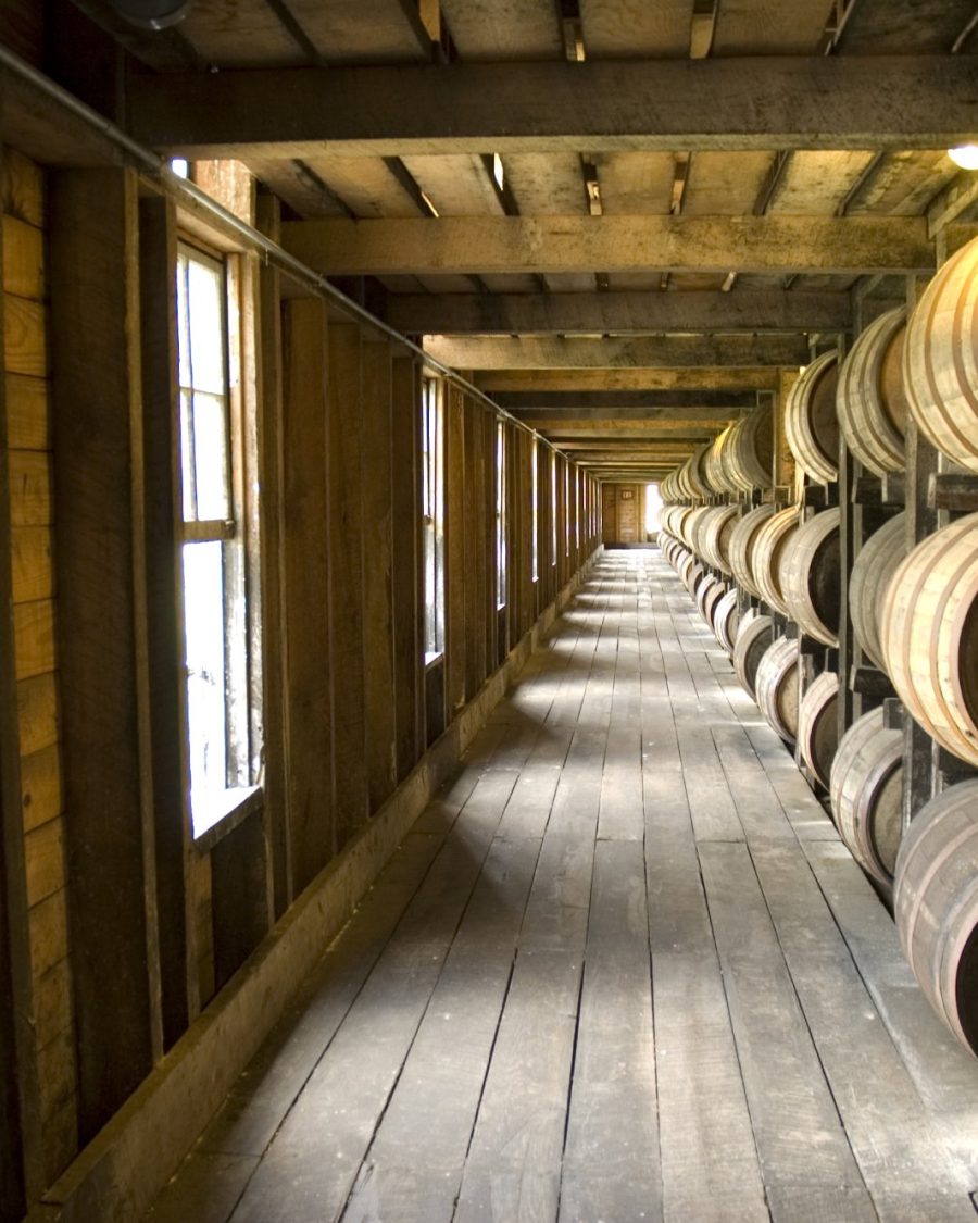 Interior of a rickhouse warehouse corridor lined with aging whiskey barrels