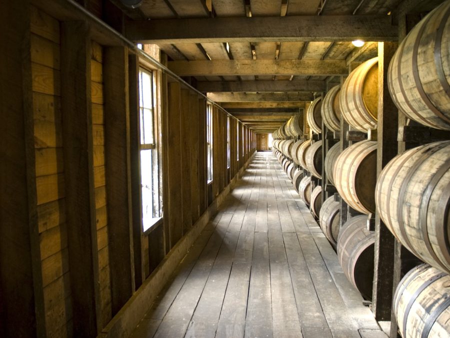 Interior of a rickhouse warehouse corridor lined with aging whiskey barrels