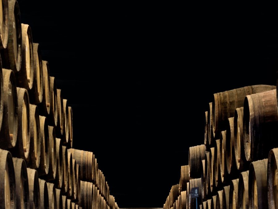 Rows of oak port pipes converging in a dim wine cellar