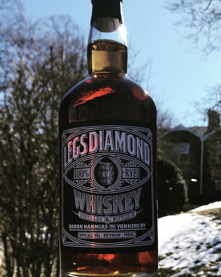 Legs Diamond 100% rye whiskey bottle held up against winter sky