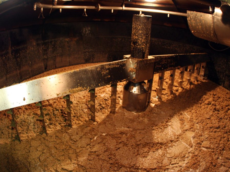 Interior of a mash tun with grain mash being stirred by rakes